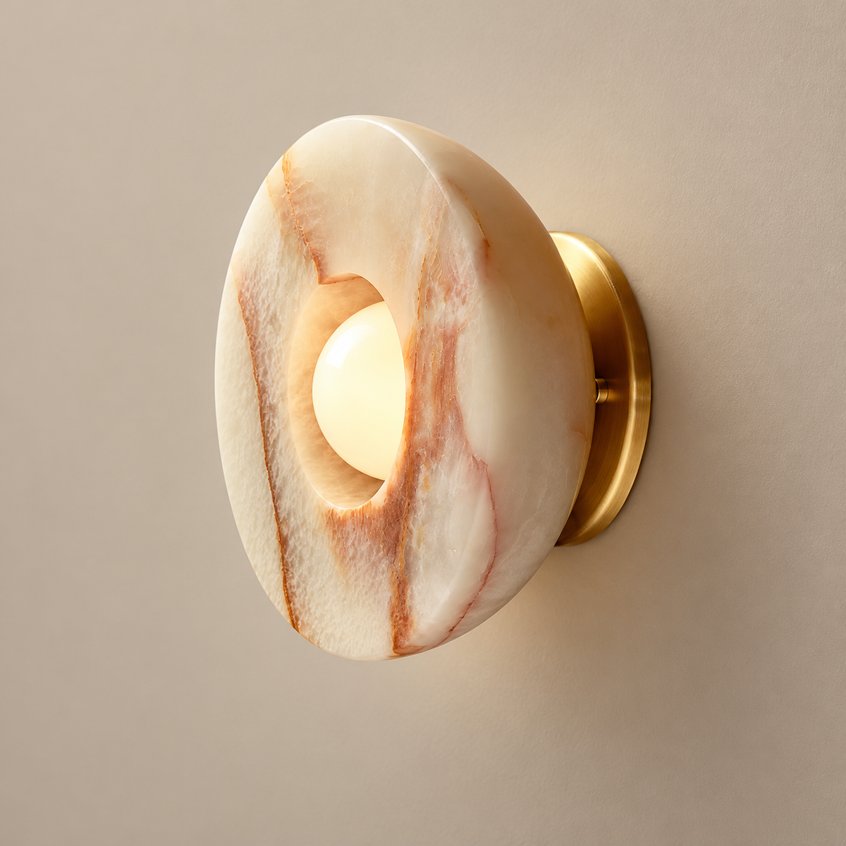 Aurelia Surface Onyx Wall Sconce on a warm greige background; Orange and Gold curved onyx doughnut shade; recessed globe