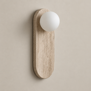 Lucie Japandi Travertine Wall Sconce on a warm greige background; Beige travertine capsule with top white opal globe