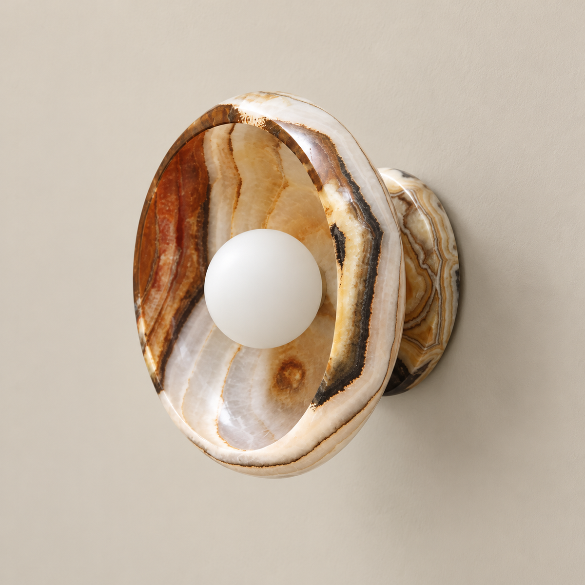 Piedra Round Marble Wall Sconce on a warm greige background; Multicolored warm brown white onyx cup and matching stone backplate