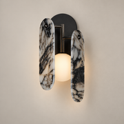Megalith Marble Globe Wall Sconce on a warm greige background; Black marble twin staggered paddles, central globe