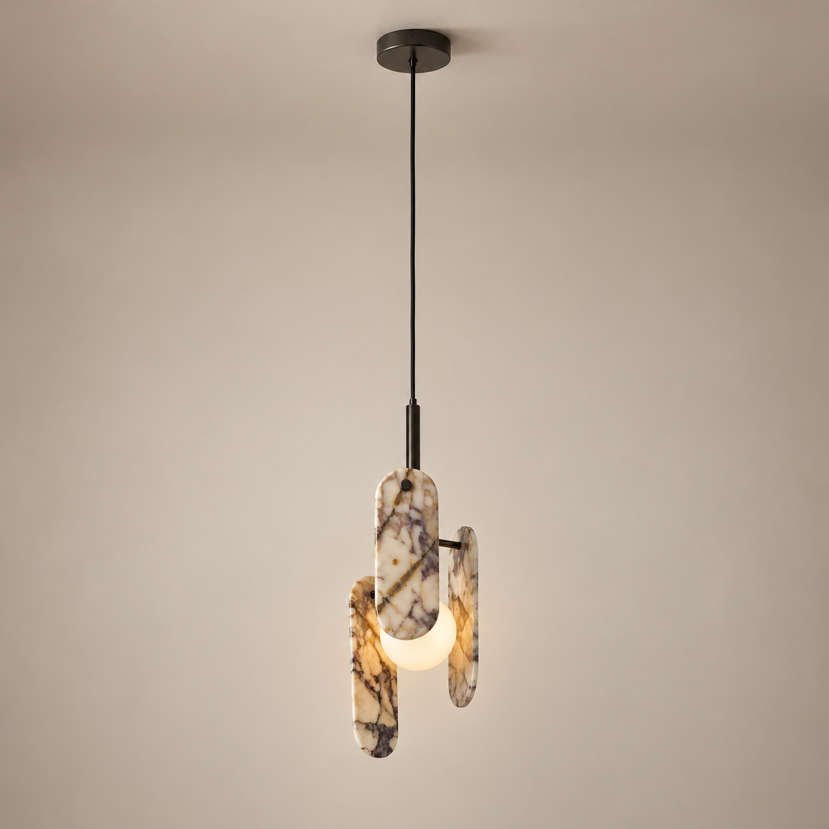 Megalith Marble Globe Pendant Light on a warm greige background; Megalith three stone paddles single hanging-wire pendant