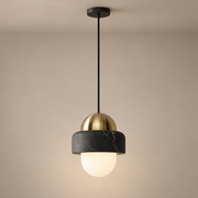 Naga Marble Pendant Light on a warm greige background; Naga black marble weathered brass single pendant