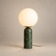 Atlas Marble Globe Table Lamp on a warm greige background; Green marble base opal glass globe on