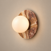 Onyx Krema Globe Wall Sconce on a warm greige background; Brown onyx and glass globe warm on