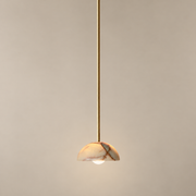 Aurelia Onyx Pendant Light on a warm greige background; Cyan onyx hemispherical shade, long solid brass rod