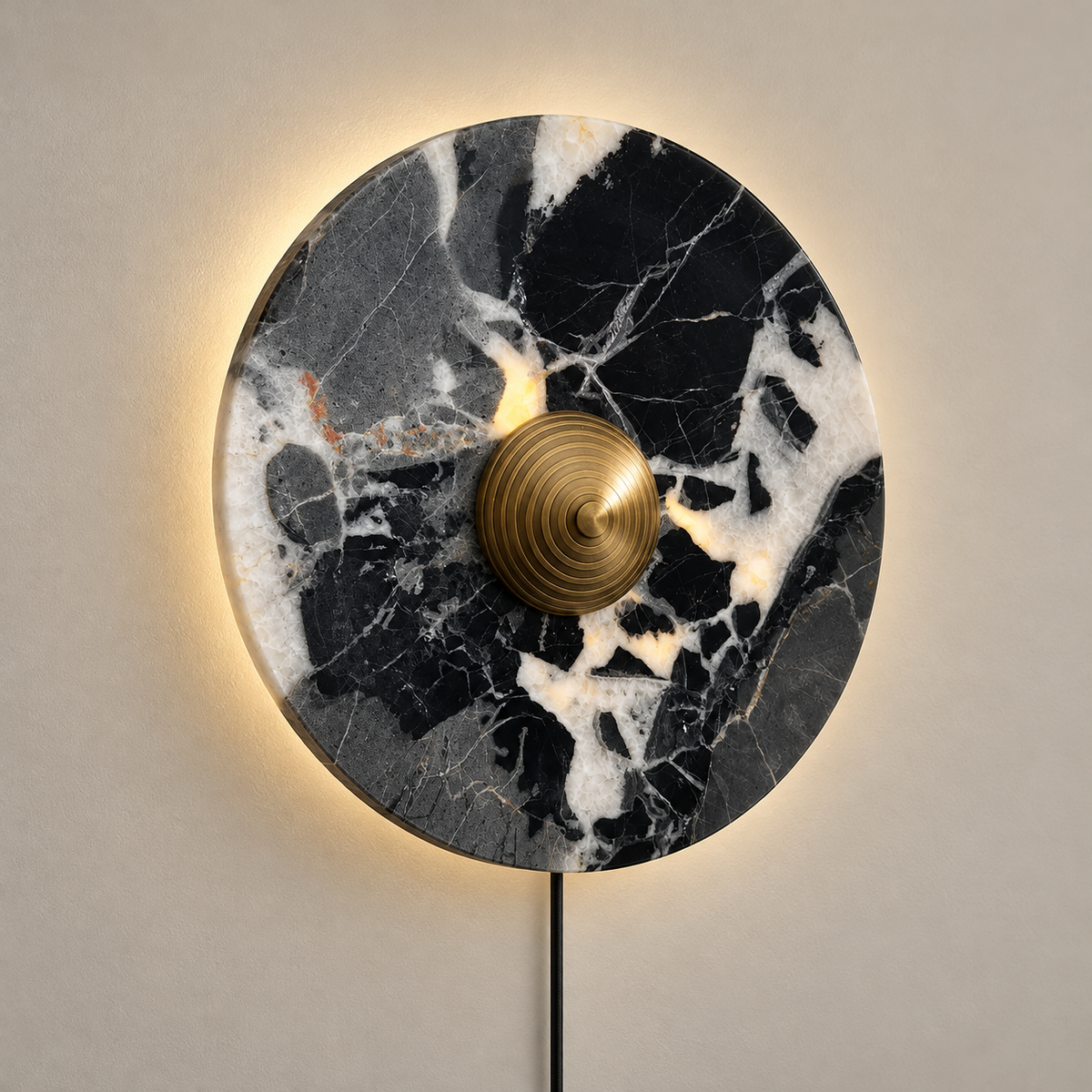 Lucie Marble Plug-In LED Wall Sconce on a warm greige background; Black white marble and concentric brass center, plug-in
