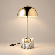 Venus Art Deco Marble Table Lamp on a warm greige background; White grey marble base and polished gold dome