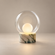 Boule Marble Table Lamp with Glass Shade on a warm greige background; White green veined marble base, clear glass globe