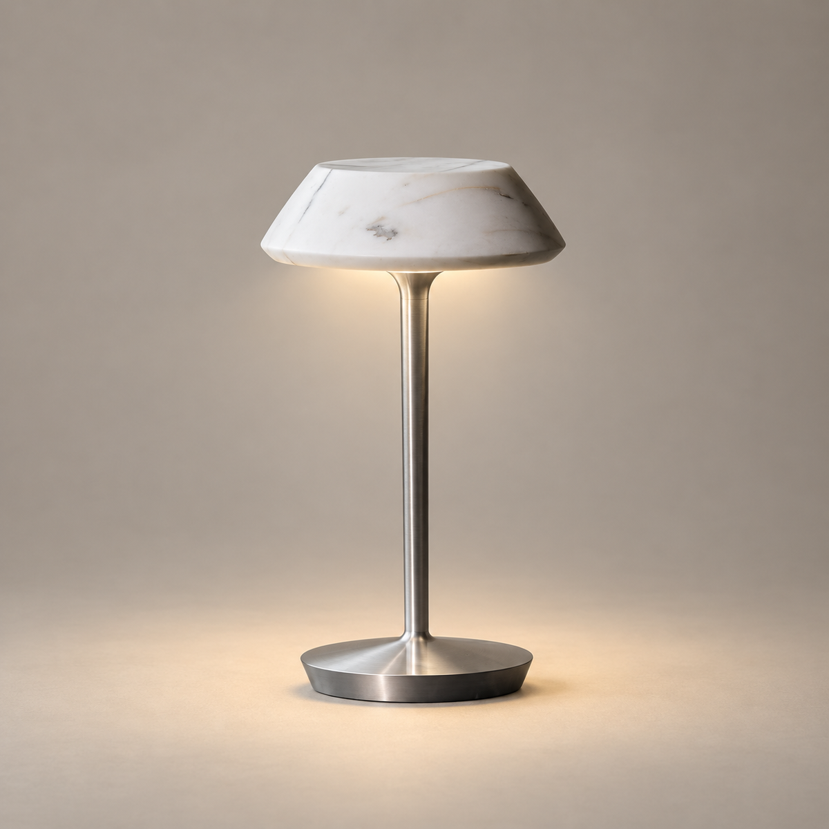 Mini Fiore Marble Rechargeable Table Lamp on a warm greige background; White marble shade, silver metal stem and circular foot
