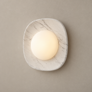Naga Marble LED Wall Sconce on a warm greige background; White grey marble rounded square with opal glass dome