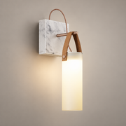 Galerie Marble Wall Sconce on a warm greige background; Tan leather handle and white marble with glowing frosted tube