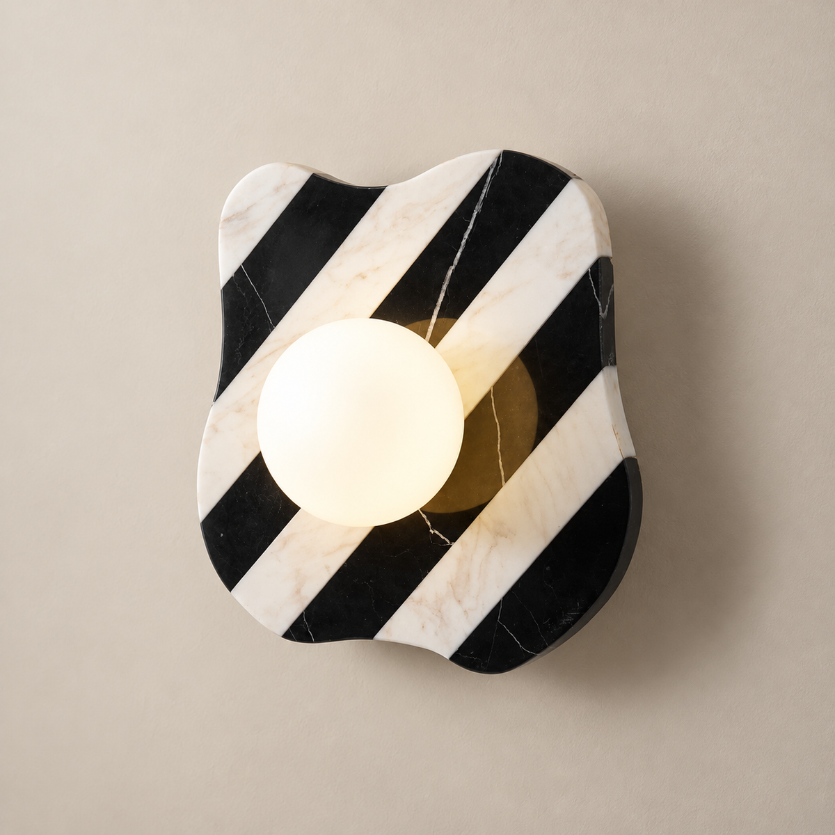 Zebra Minimalist Marble Wall Sconce on a warm greige background; Zebra marble wall sconce with warm glass globe