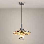 Veined marble disc pendant with a long black cord and chrome hardware mounted to a ceiling