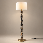 Nizwa Traditional Marble Floor Lamp on a warm greige background; Seven stacked marble cones white drum floor lamp