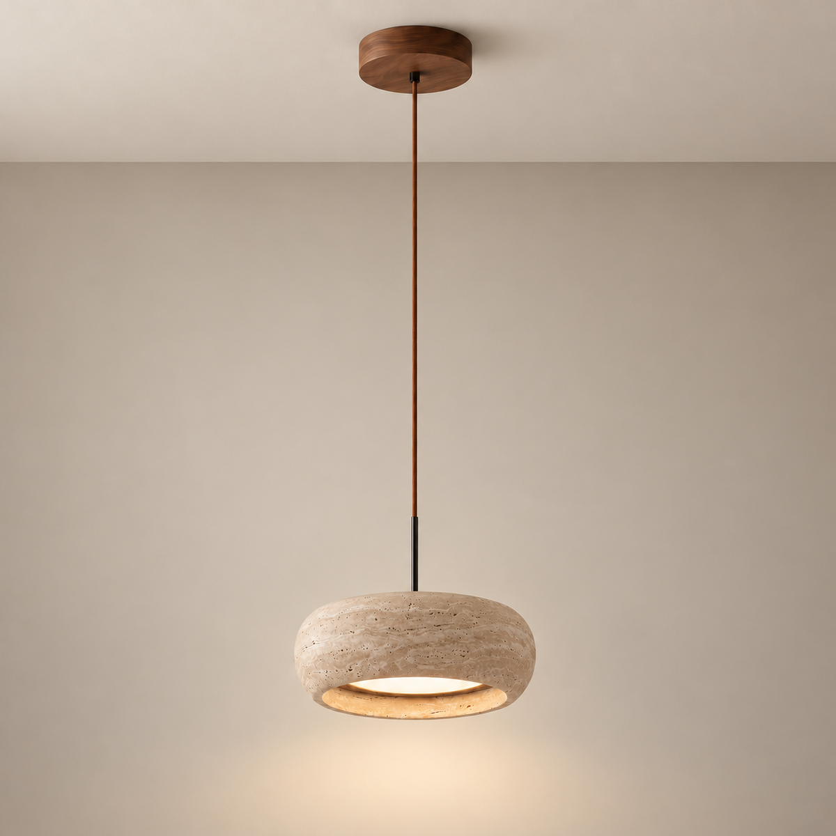 Beige travertine drum pendant with walnut canopy and a long cord mounted to a ceiling