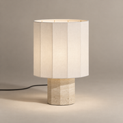 Roma Art Deco Dodecagon Travertine Table Lamp on a warm greige background; Small white shade beige faceted base