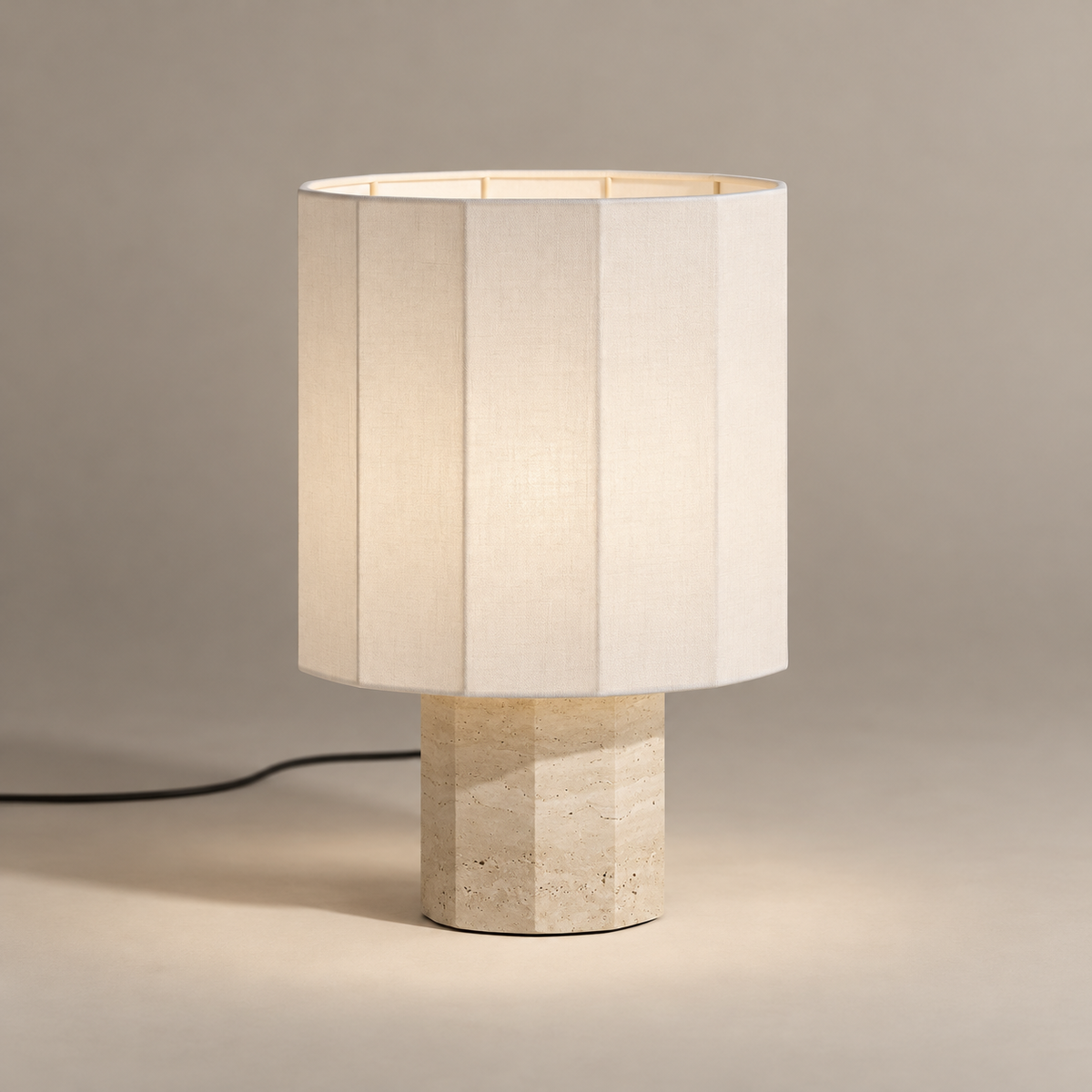 Roma Art Deco Dodecagon Travertine Table Lamp on a warm greige background; Small white shade beige faceted base