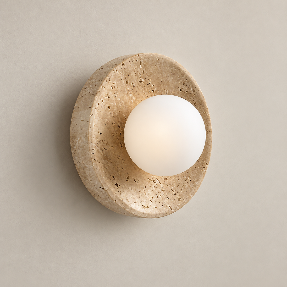 Calvora Travertine Globe Wall Sconce on a warm greige background; Beige circular dish white globe