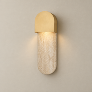Hudson Travertine Wall Sconce on a warm greige background; Brass arch hood beige capsule