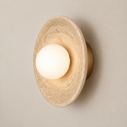 Eretoq Travertine Globe Wall Sconce on a warm greige background; Model A concave stone disk globe