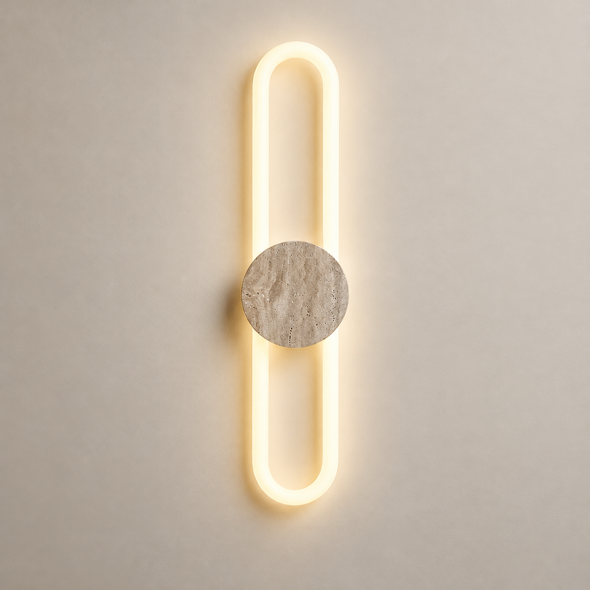 Ra Travertine LED Wall Sconce on a warm greige background; Model B centered stone disk white capsule loop