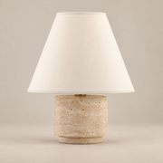 Bronte Travertine Table Lamp on a warm greige background; Bronte beige stone base / cream cone fabric shade