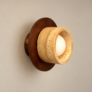 Logatec Japandi Travertine Wall Sconce on a warm greige background; Logatec walnut disc / thick beige ring / recessed globe