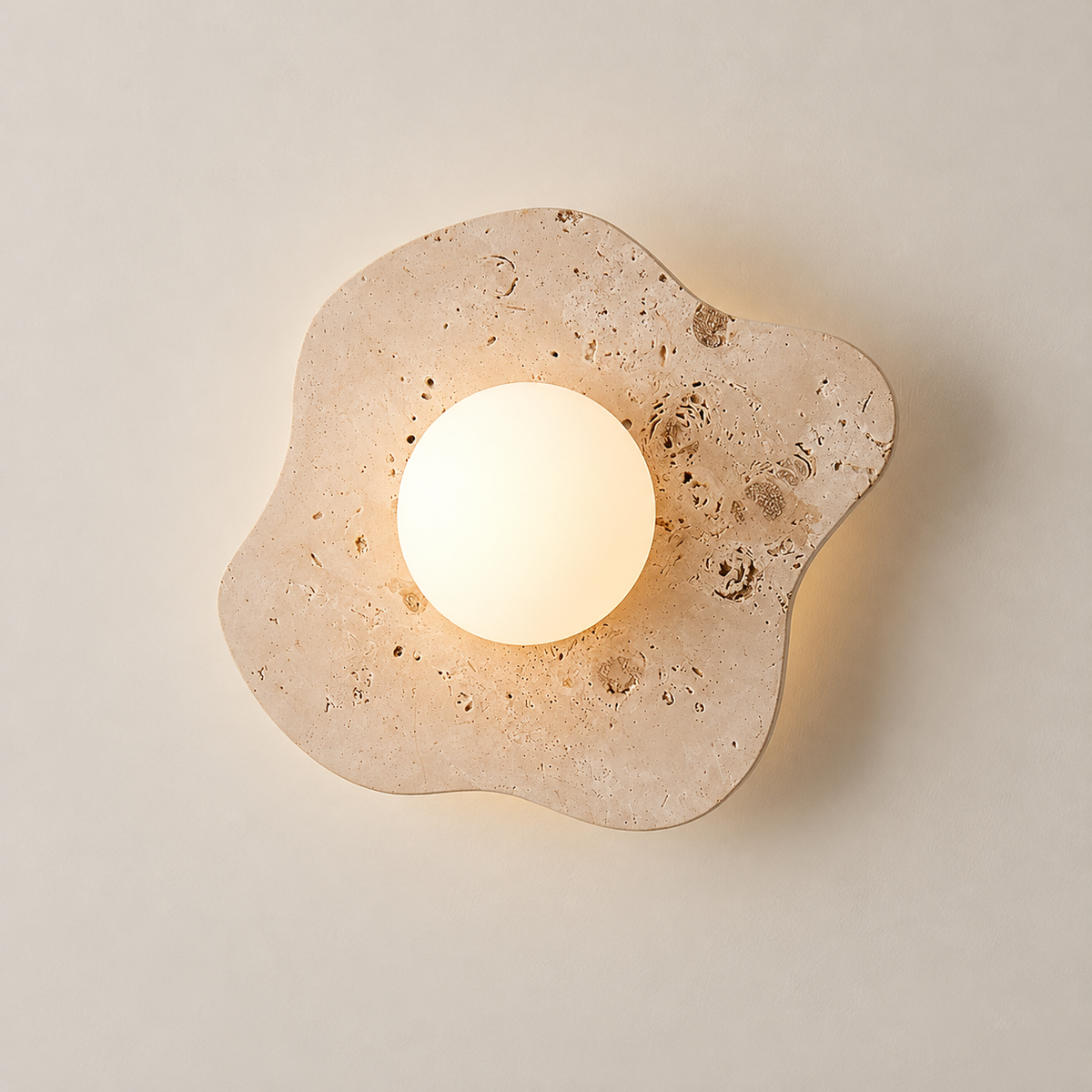 Blob Japandi Travertine Wall Sconce on a warm greige background; Beige organic plate and white globe