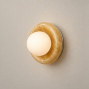 Novi Organic Modern Onyx Wall Sconce on a warm greige background; Yellow onyx and white globe
