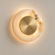 Ethereal Moon Onyx LED Wall Sconce on a warm greige background; White onyx and brushed brass disk