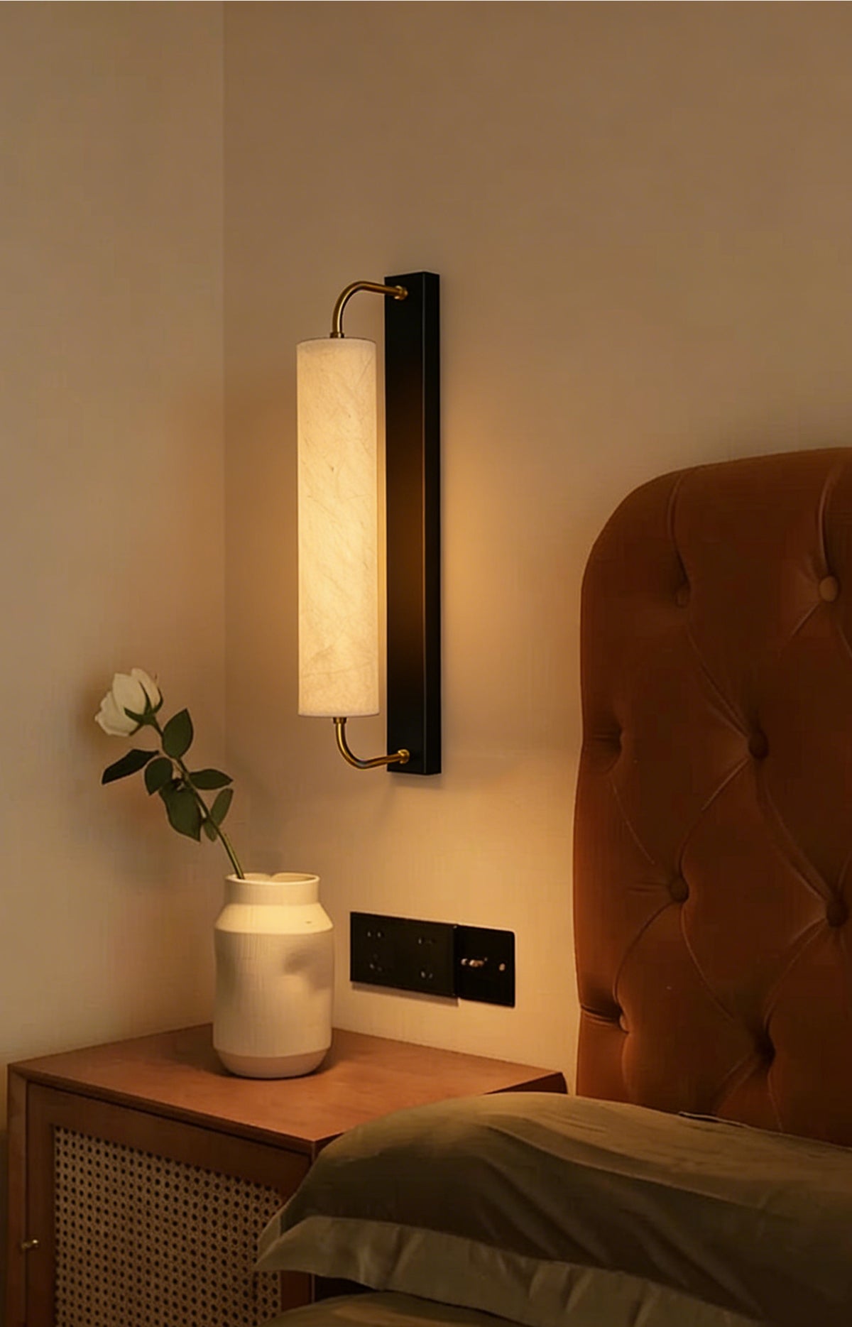Mulberry silk cylinder wall sconce beside a bed