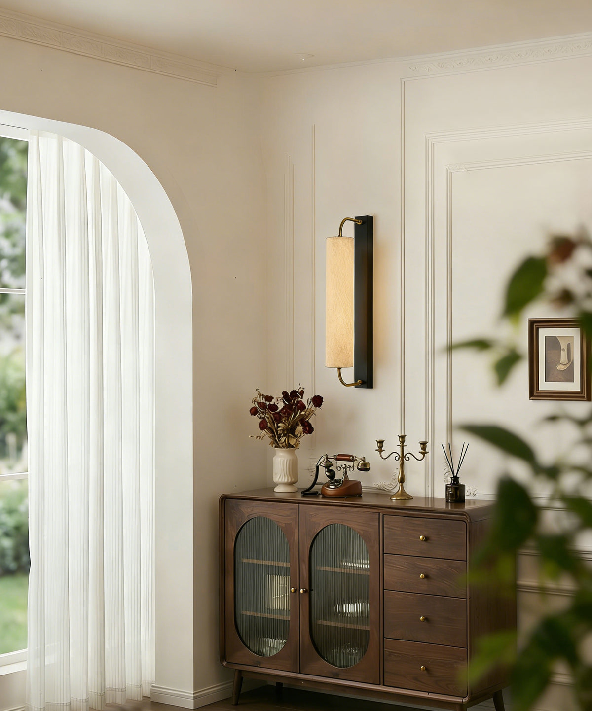 Mulberry silk cylinder wall sconce above a wood cabinet