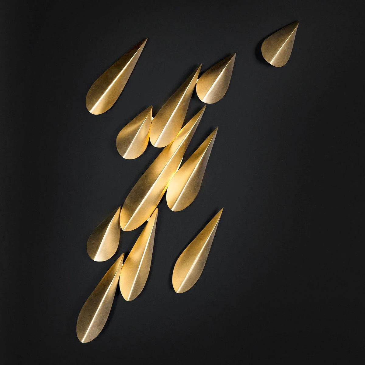 1273 11-leaf brass wall light illuminated against a dark background