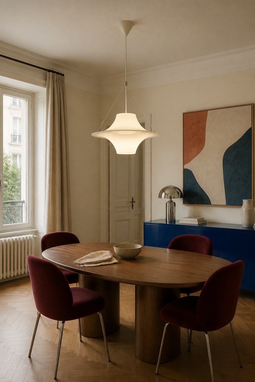 White acrylic saucer pendant above a walnut dining table with burgundy chairs