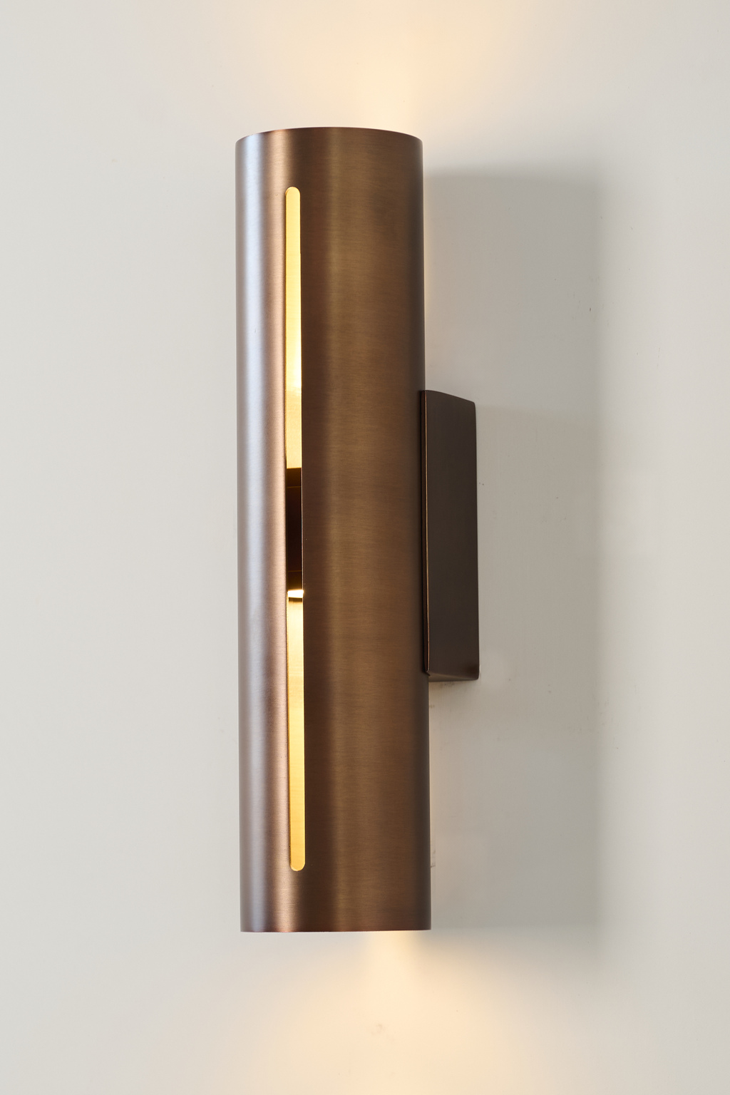 Short antique copper cylinder wall sconce, illuminated front view