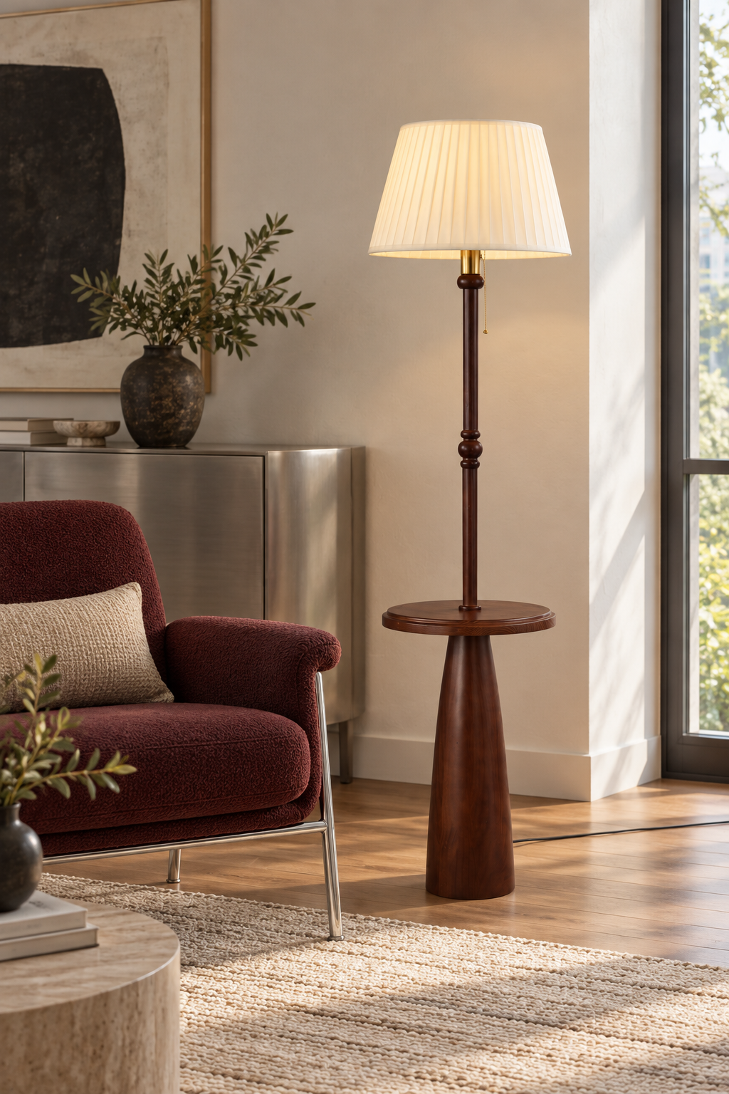 Ornvale - Pleated floor lamp illuminated beside a burgundy chair and brushed-metal cabinet