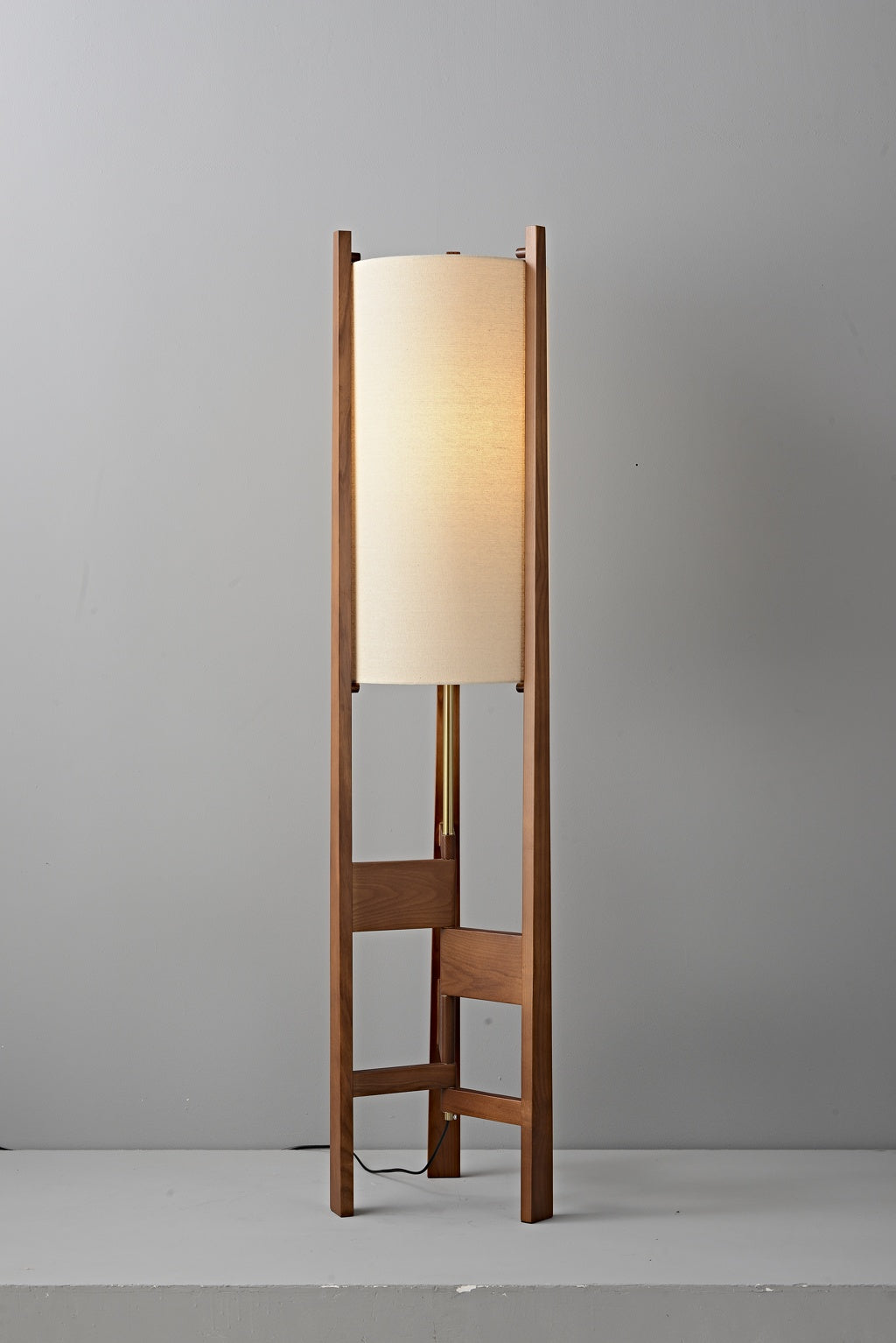 Ashverelle ash wood floor lamp — warm-lit fabric shade and full wood frame