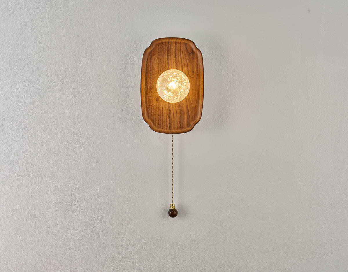 Front view of the rounded walnut backplate and textured glass globe in an actual photograph