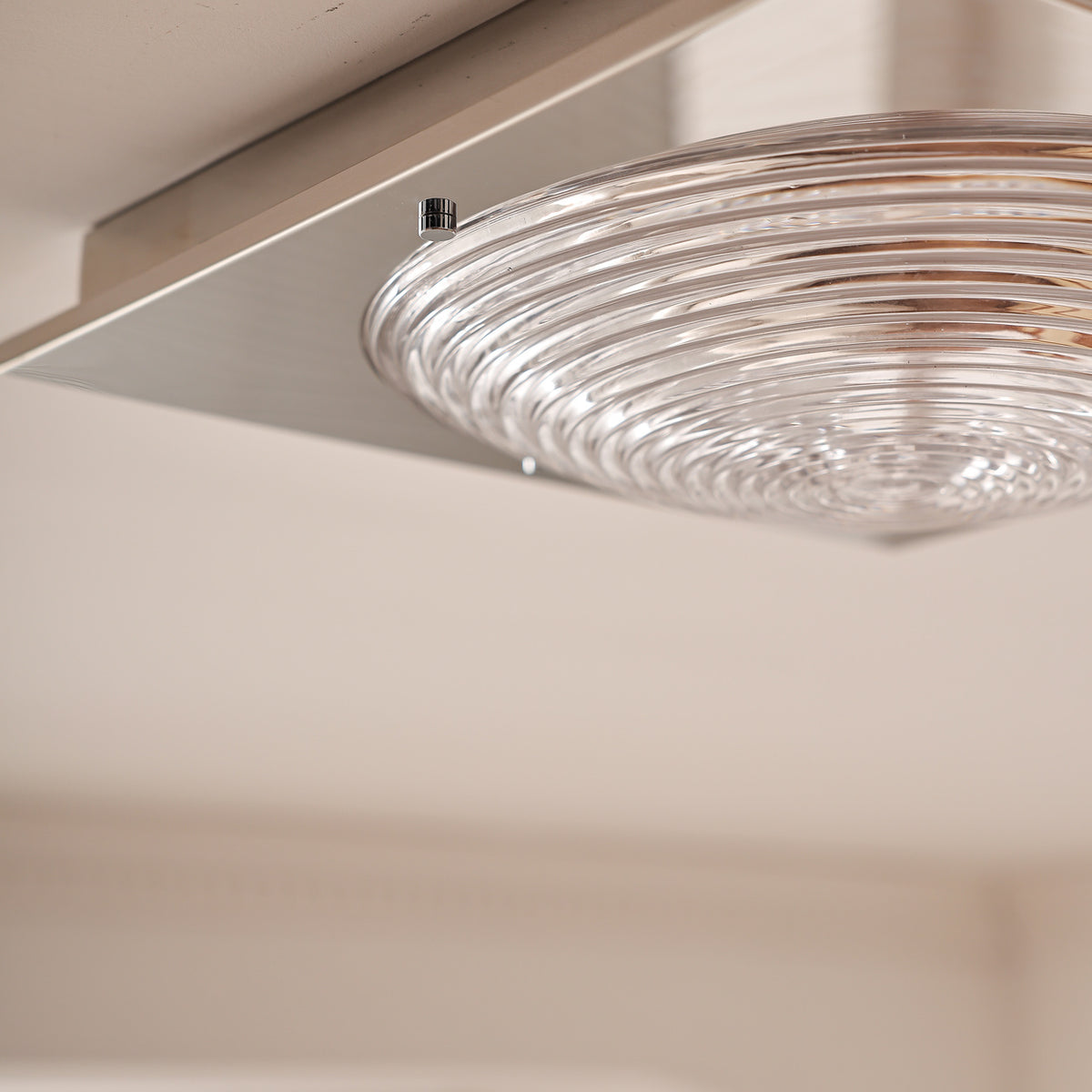 Close-up of unlit clear glass, retaining pin and mirror steel plate