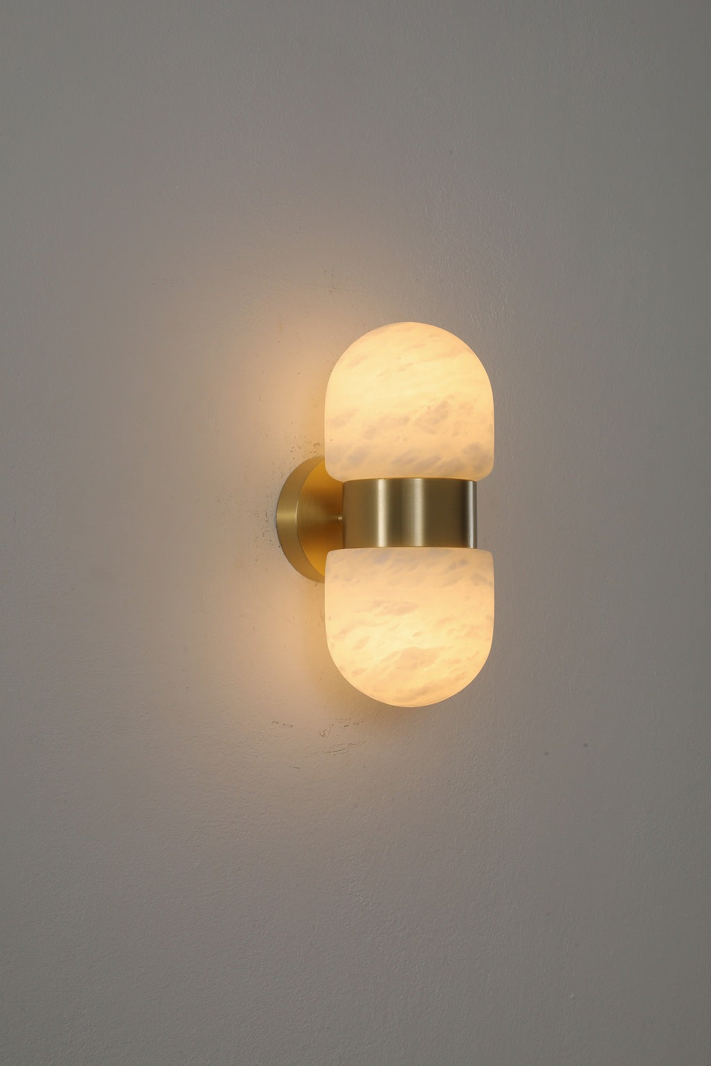 Alabaster Double Capsule Wall Sconce — Natural copper finish illuminated, original product photograph