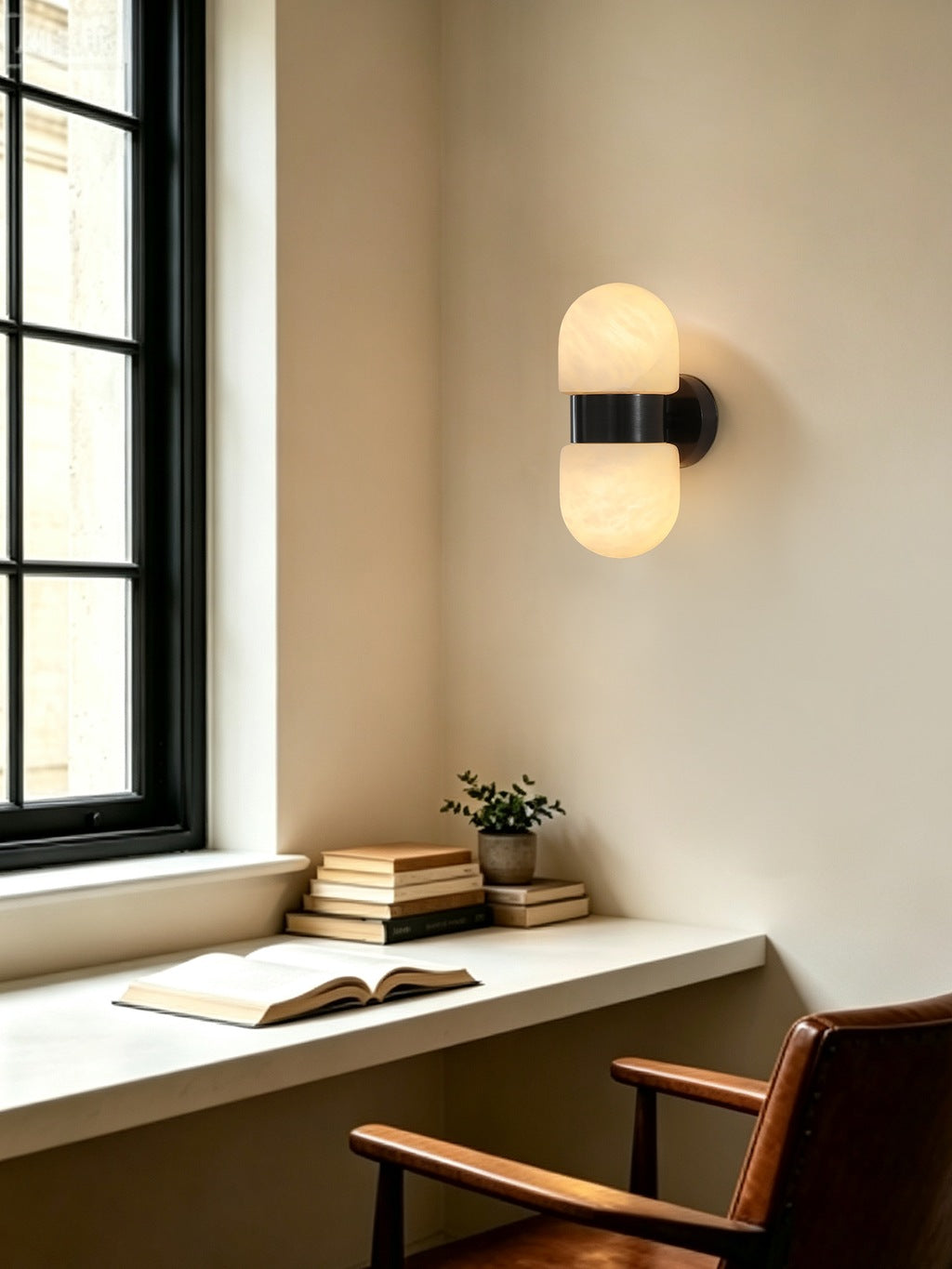 Alabaster Double Capsule Wall Sconce — Black sconce in a study by a window