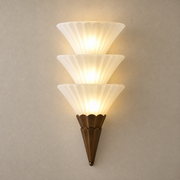 Fanelisse fluted glass wall sconce in Antique Bronze - Three-tier hero on a warm beige wall