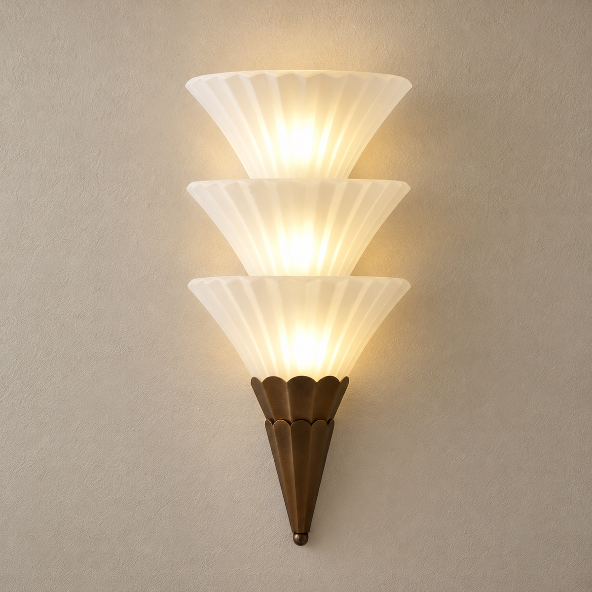 Fanelisse fluted glass wall sconce in Antique Bronze - Three-tier hero on a warm beige wall