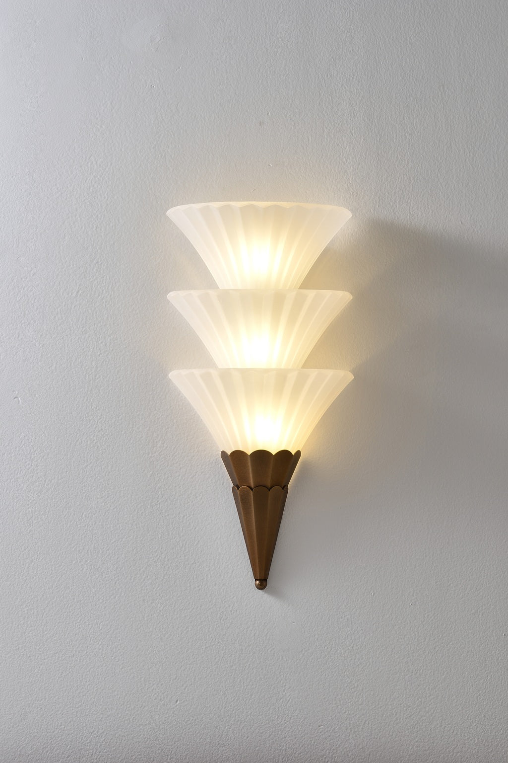 Fanelisse fluted glass wall sconce in Antique Bronze - Three-tier actual front view, warm light