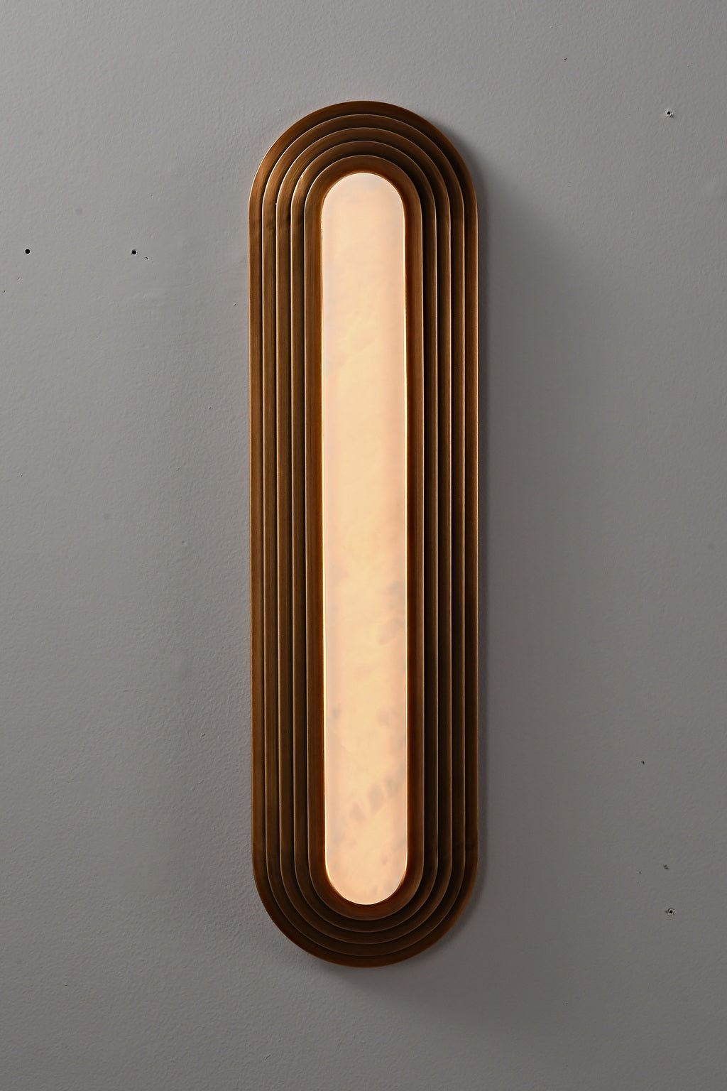 Real photograph of the bronze-finish alabaster wall sconce illuminated