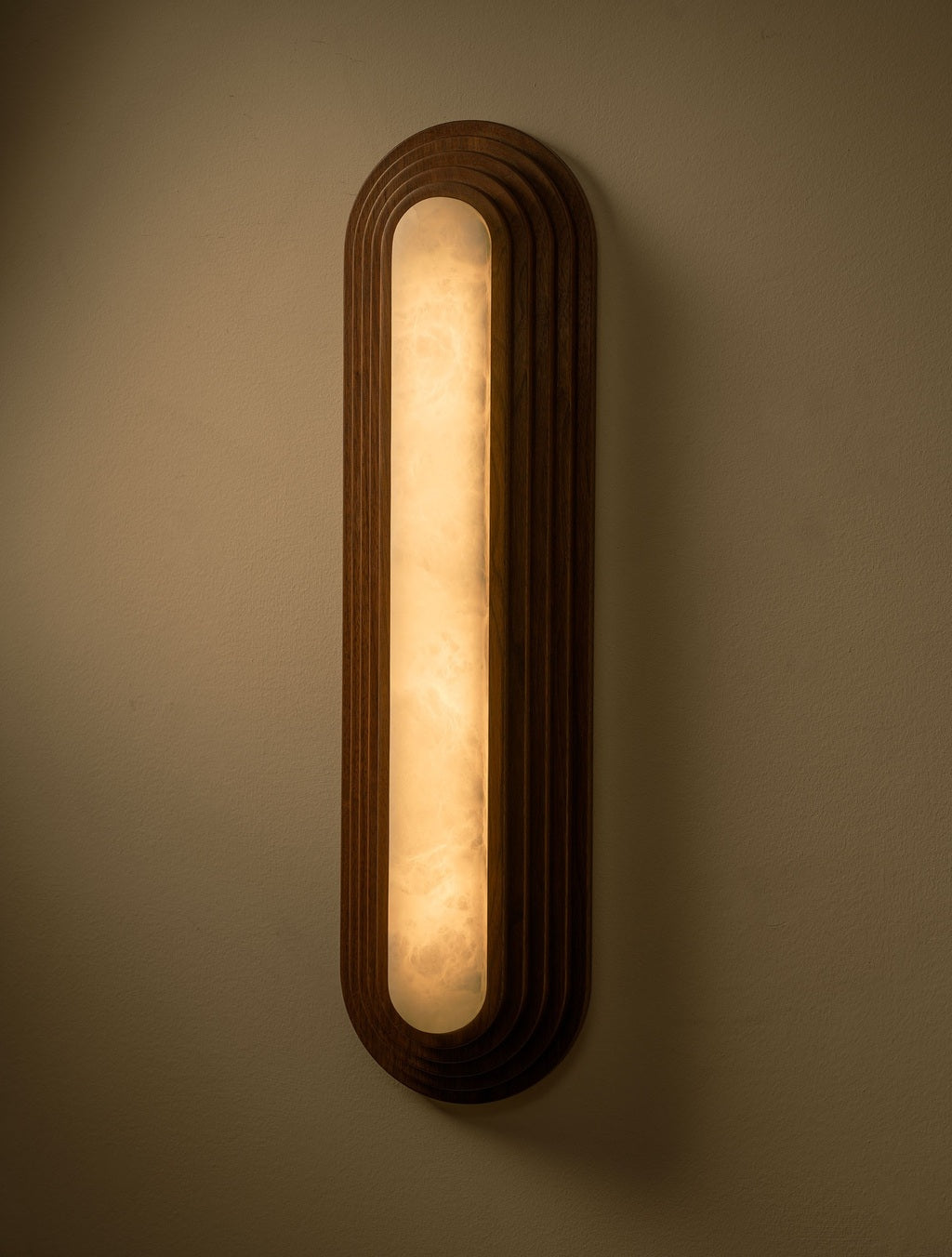 Real photograph of the black walnut alabaster wall sconce illuminated