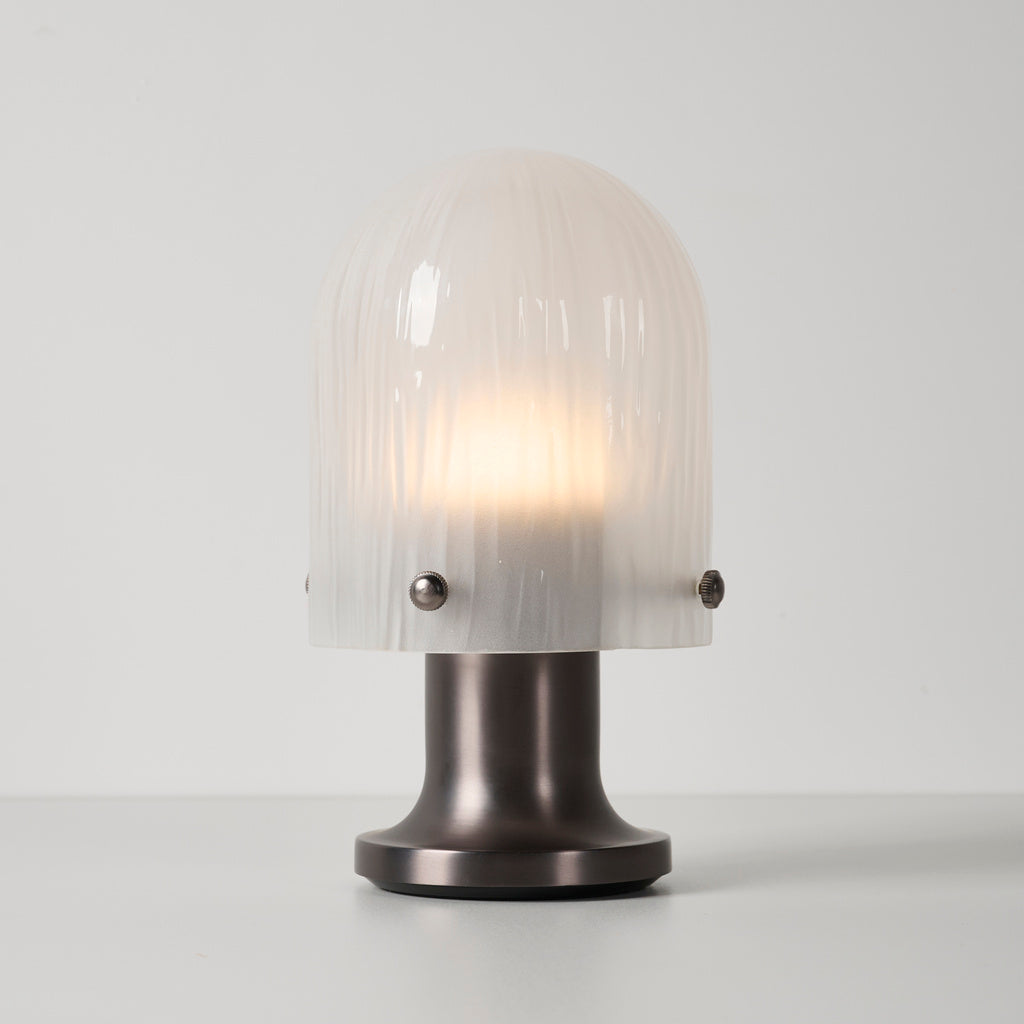Mernoval glass table lamp illuminated on a neutral tabletop