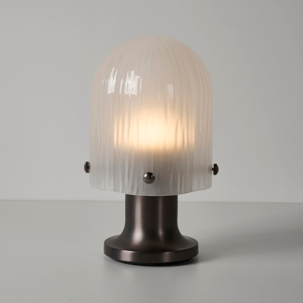 Illuminated Mernoval glass table lamp viewed from a side angle