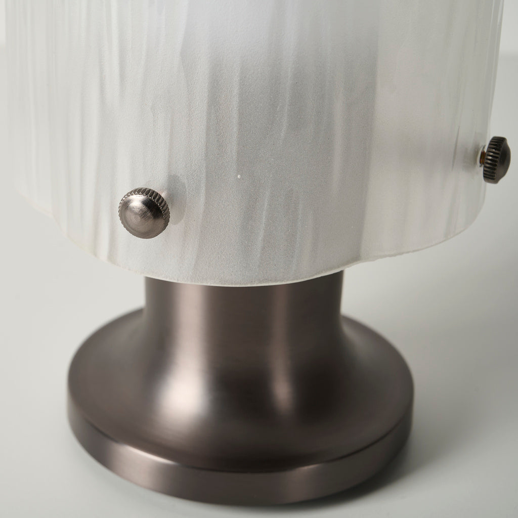Close-up of the glass-shade fixing knobs and flared metal base of Mernoval table lamp
