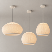 Three illuminated ribbed textile pendant silhouettes displayed with a male model in a warm modern interior